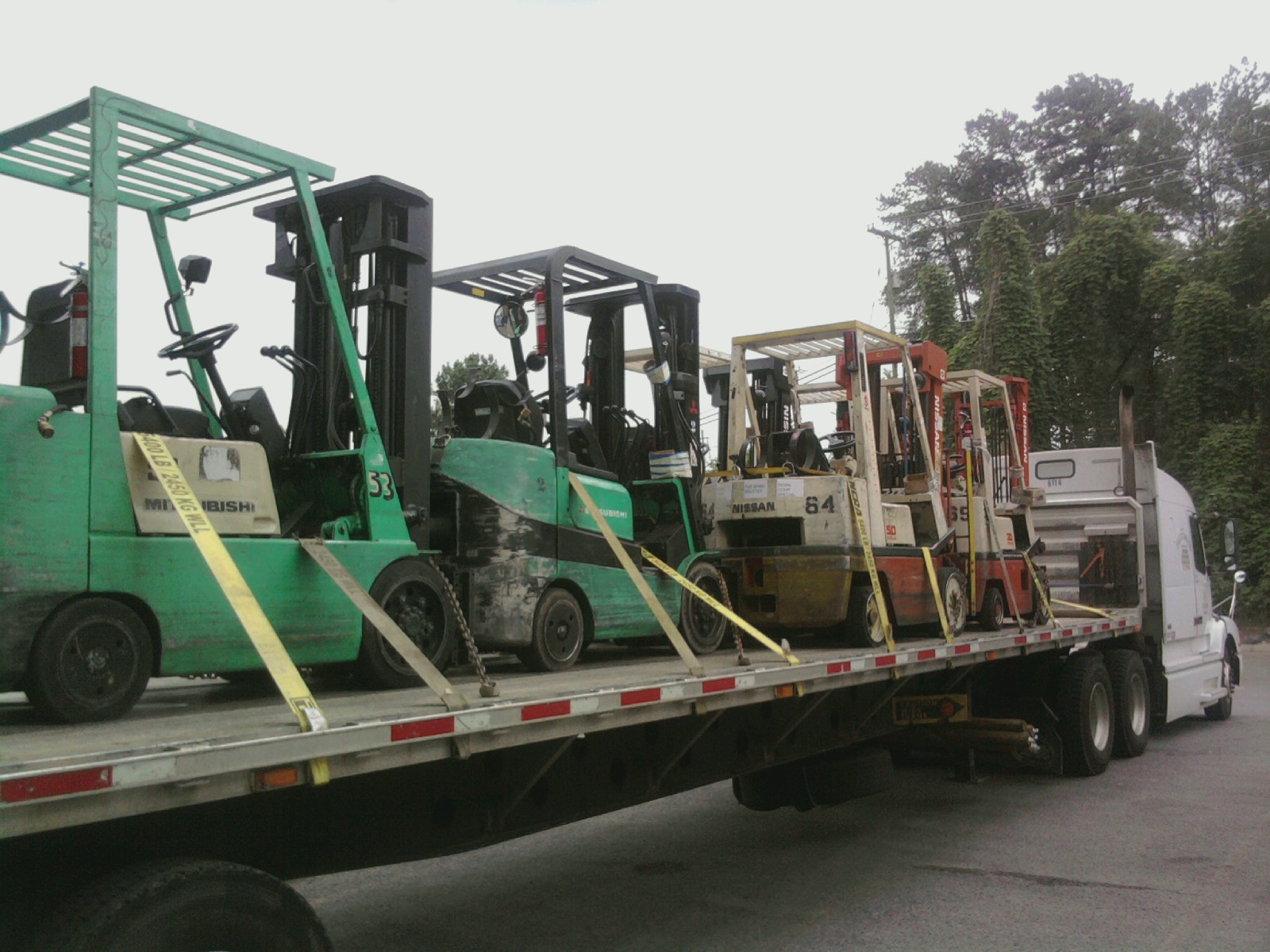Large forklift transported on flatbed trailer